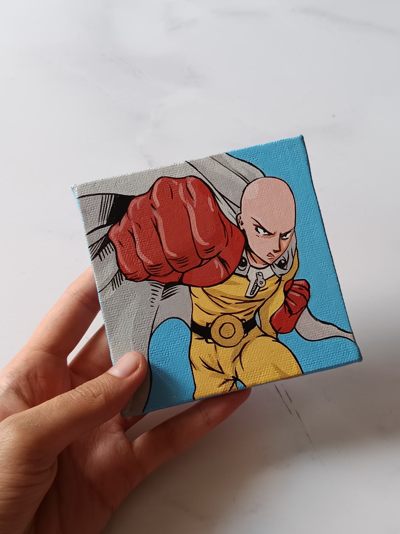 Side view of Saitama hand-painted mini canvas fridge magnet by Tulika Viegas