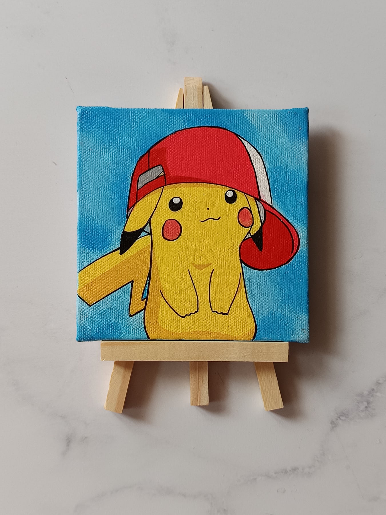 Side view of Pikachu with Cap hand-painted mini canvas fridge magnet by Tulika Viegas