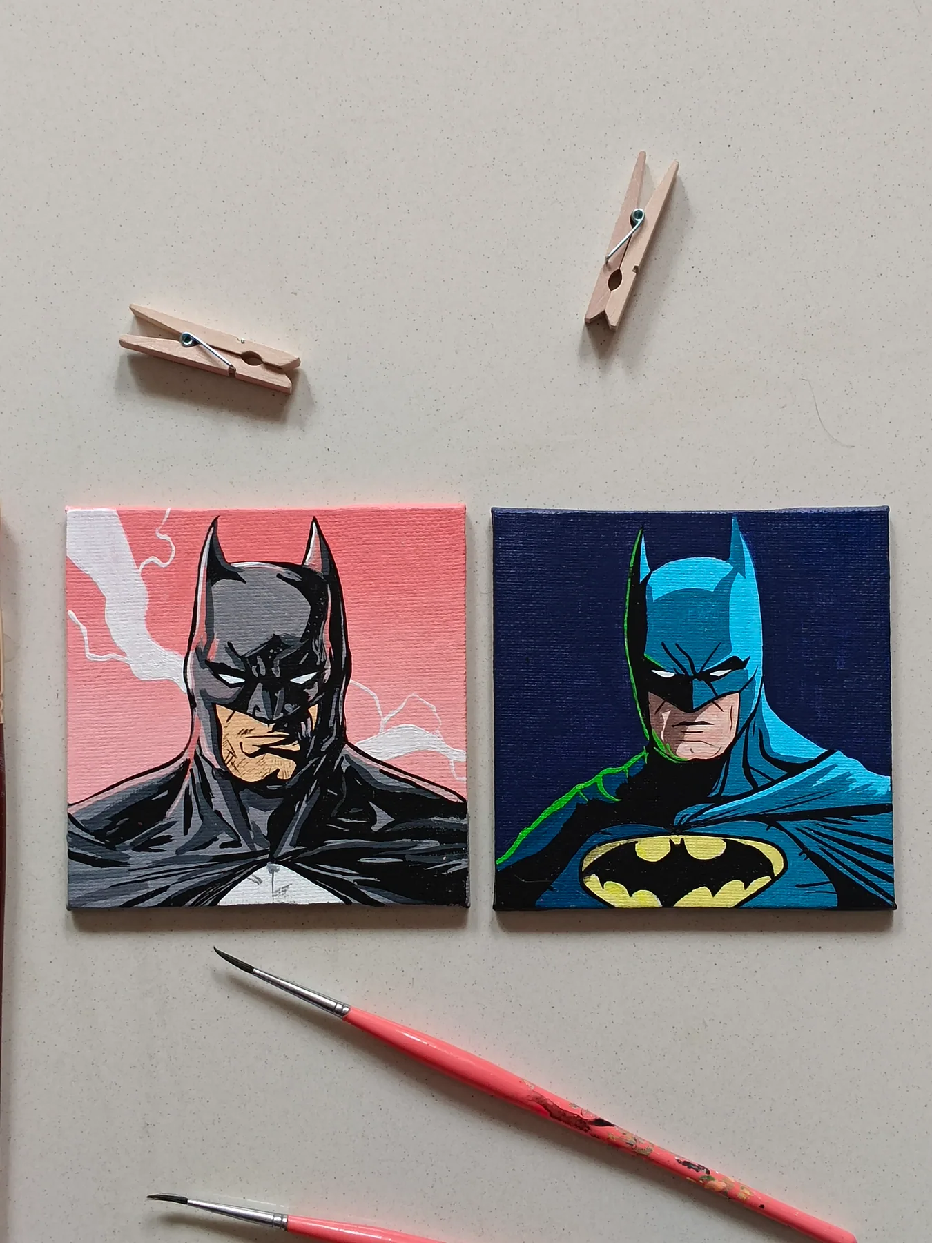 Pair of hand-painted acrylic mini canvases featuring Batman from DC Comics in dark comic-book scenes, displayed with brushes and clips.