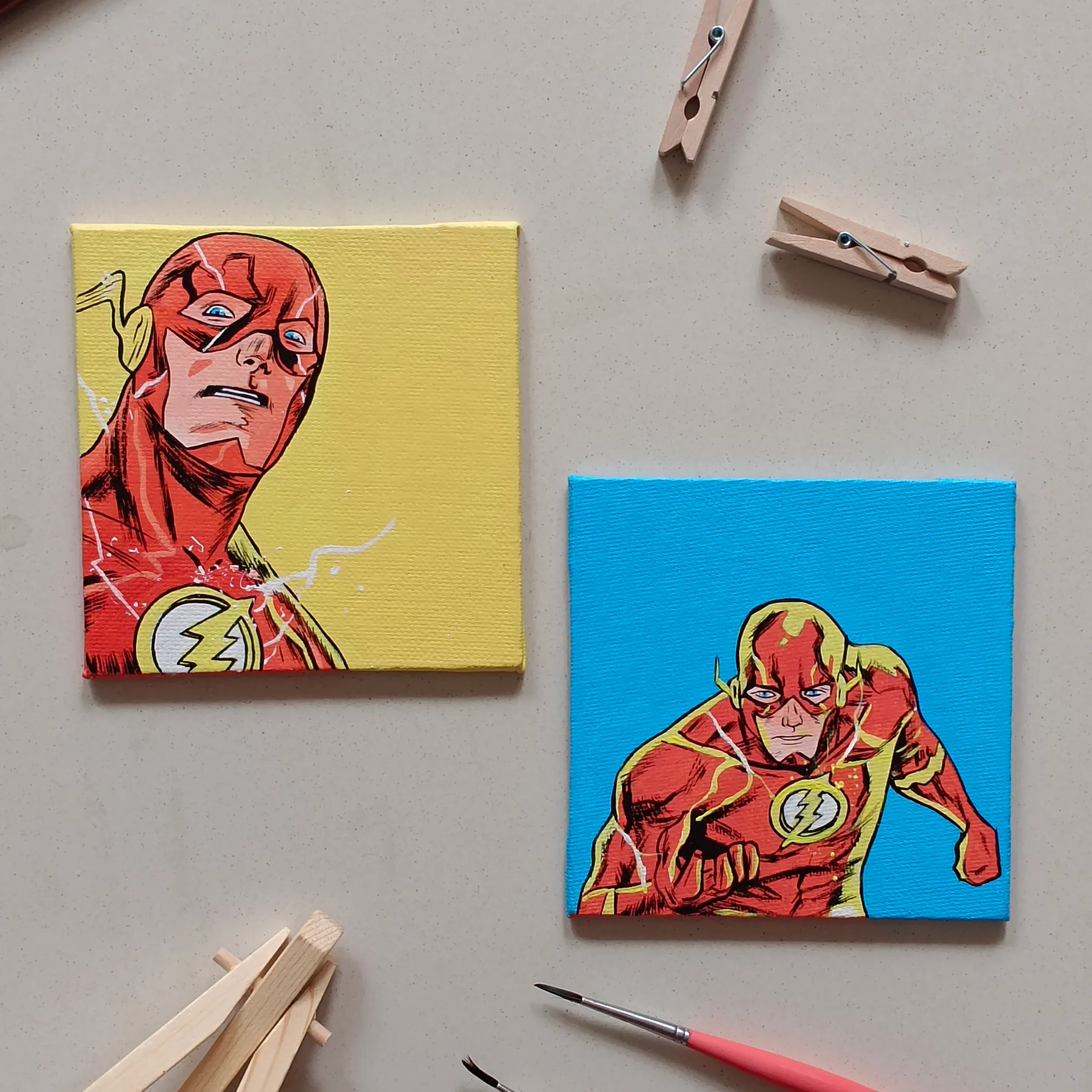 Pair of hand-painted acrylic mini canvases featuring The Flash from DC Comics in two red-suit poses on bright backgrounds.