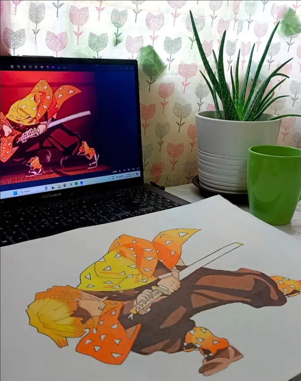 Zenitsu Agatsuma fan artwork from Demon Slayer in progress on paper beside the laptop reference used by Tulika Viegas.