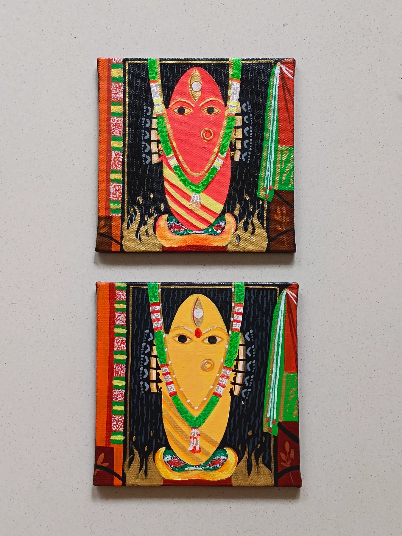 Pair of Bhairavi Devi inspired mini canvas paintings in red and yellow, displayed together on a wall.