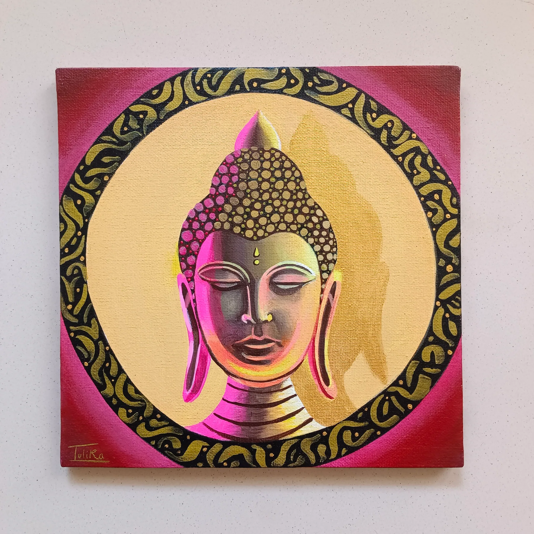 Small acrylic canvas painting of Buddha in pink and gold tones, framed by a circular ornamental border.